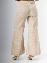 Pantalón palazzo de tiro alto, color beige con estampado de cachemir en blanco.