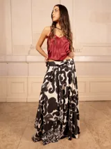 Falda larga acampanada con estampado de espirales en blanco y negro, cuenta con un lazo ajustable en la cintura.