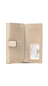 Billetera larga de símil cuero color marrón claro, con solapa frontal decorada con un aro metálico central. Cuenta con múltiples compartimentos internos para tarjetas, billetes y un monedero con cierre.