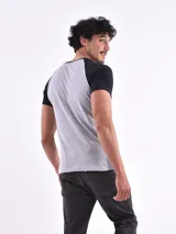 Remera gris con mangas raglán negras y estampado frontal con la inscripción "California Westcoast" en amarillo y un diseño de raquetas de tenis.