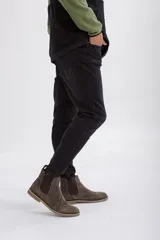 Pantalón de jean corte slim fit en color negro lavado, con cierre de botón y cremallera, y bolsillos laterales y traseros.