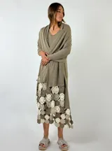 Pashmina larga color tostado, confeccionada en tejido de punto ligero, con un diseño que presenta un borde inferior decorado con aplicaciones de crochet en tonos tierra y crema.