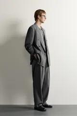 Blazer gris de corte relaxed fit con diseño de raya diplomática, cuello con solapas de pico, doble botonadura cruzada y bolsillos con solapa en la cadera.