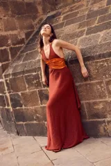 Vestido largo con pechera de cuero metalizado y falda tejida con hilo de lurex brillante. Presenta un diseño de cuello halter y corte fluido.