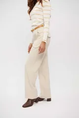 Pantalón de vestir color beige claro, tiro alto, de corte ancho y pierna recta.