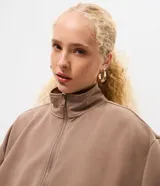 Campera de modal color marrón, con cuello alto, cierre frontal completo y diseño con pliegues en el ruedo. Presenta mangas largas y un calce holgado.