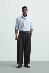 Camisa de manga larga color celeste claro, corte regular fit, con cuello solapa, bolsillo plastrón en el pecho y cierre frontal de botonadura.