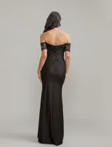 Vestido largo de fiesta color negro con corset estructurado de encaje y lentejuelas, escote off-shoulder y falda con tajo lateral profundo.