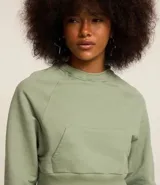Buzo cropped color verde claro, de algodón y poliéster, con cuello redondo, mangas largas y bolsillo canguro.