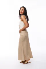 Falda larga de jean color beige, corte recto con vuelo en el ruedo y costuras verticales a lo largo de la prenda.