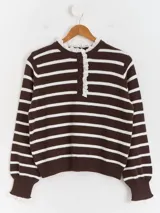 Sweater de punto a rayas horizontales en color bordó y blanco, con cuello tipo polo, cierre frontal con botones y delicados detalles de puntilla blanca en el cuello y los puños.