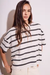 Remera de algodón color crudo con rayas horizontales negras, corte holgado y mangas cortas.