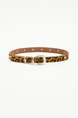 Cinturón de cuero vacuno con acabado de pelo animal print, de 2,5 cm de ancho. Presenta remaches metálicos en forma de corazón, hebilla, pasador y puntera metálica en tono plata.
