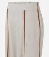 Pantalón largo tipo palazzo de color beige, confeccionado en mezcla de viscosa y lino. Presenta tiro alto, cintura elastizada en la parte posterior y aberturas frontales en las piernas con ribetes en tono marrón contrastante.