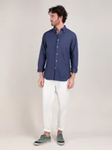 Camisa lisa de hombre confeccionada en algodón, tintada en prenda con acabado vintage. Presenta corte regular fit, cuello buttondown, cierre frontal de botones, manga larga con puño simple y logo bordado en el pecho.