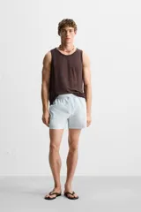 Short de baño celeste con estampado geométrico paisley, cintura elástica con cordón ajustable, bolsillos laterales y bolsillo trasero.