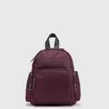 Mochila Bubba modelo Victoria color bordó, confeccionada en material sintético resistente con detalles en cuero vegano. Cuenta con un compartimento principal con cierre, un bolsillo frontal amplio con cierre y dos bolsillos laterales con cierre. Incluye asa superior y correas ajustables.