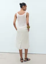 Top sin mangas de tejido de punto con diseño de crochet y cuello escotado.