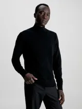 Sweater negro de cuello perkins confeccionado en lana merino extrafina. Tiene cuello, puños y bajo de canalé.