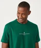 Remera de corte comfort color verde, con cuello redondo y manga corta. Presenta un pequeño estampado minimalista en el centro del pecho con la inscripción 'Nautique des Regates'.