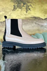 Bota Chelsea de cuero color beige con elástico lateral negro, detalle de costuras en la puntera y suela track negra.