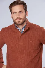 Buzo de tejido grueso color gris, con cuello alto y cierre frontal parcial. Presenta puños y ruedo acanalados, con un diseño de textura tejida en toda la prenda.