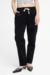 Pantalón de pana negro con cintura elastizada y cordón de algodón. Cuenta con bolsillos laterales, un bolsillo trasero y el patch característico de Polonio.