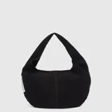 Cartera tipo hobo con diseño en forma de media luna, confeccionada en tela de acabado rústico color negro. Presenta una costura central vertical y una etiqueta lateral blanca con detalles impresos.
