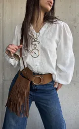 Camisa blanca de manga larga abullonada, con delicados bordados frontales y cierre con botones.