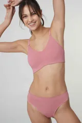 Sostén tipo bralette color beige, de tela acanalada, con breteles ajustables, doble tela y espalda con broche de tres medidas. Sin relleno ni aro.