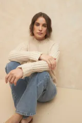 Polera de tejido de punto acanalado color marrón, con cuello alto y mangas largas con puños doblados.