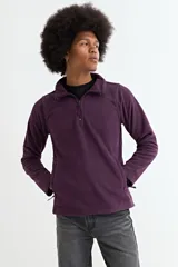 Buzo de polar color violeta, con cuello alto y cierre frontal parcial, de manga larga y bolsillos laterales.