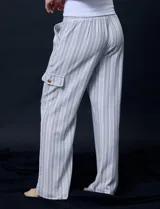 Pantalón cargo de lino a rayas verticales grises y blancas, marca Marissa Olivia. Pretina ancha elastizada con lazo de ajuste, bolsillos inclinados delanteros y bolsillos laterales con botón.