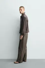 Pantalón de corte balloon fit confeccionado en piel, con bolsillos delanteros y traseros de vivo, cierre frontal con cremallera y botón.