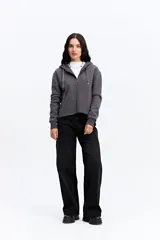 Campera tipo hoodie de algodón en color gris oscuro, con cierre frontal completo, capucha con cordones ajustables y bolsillos laterales. Presenta un diseño minimalista con logo bordado sutil en el pecho.