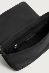 Bandolera de tejido técnico liso en color negro, con compartimento principal con cierre de imán y asa de hombro ajustable con detalle de cordón.