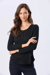 Remera de manga larga color negro, con cuello redondo y cierre frontal parcial con botones a tono. Presenta un diseño de corte recto con ruedo curvo.