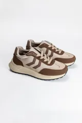 Zapatilla acordonada de estilo urbano, combinando tonos beige y marrón, con paneles superpuestos y suela de plataforma dentada.