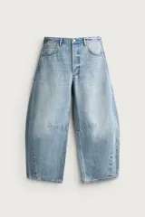 Jeans de hombre corte barrel fit confeccionados en denim de algodón celeste con efecto lavado. Presentan diseño amplio, tiro medio, cierre frontal con cremallera y botón, y detalles de pinzas en rodillas.