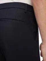 Pantalón de vestir azul marino, de corte slim, con bolsillos laterales y traseros.