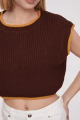 Chaleco corto de punto color marrón con ribete amarillo en cuello, sisas y bajo.