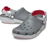Zuecos Crocs modelo Classic Clog Turbo, color gris con suela blanca y detalles en rojo. Cuenta con perforaciones superiores para ventilación, correa trasera ajustable con sistema turbo y suela de goma para mayor tracción.