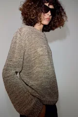 Jersey de punto con hilo metalizado, cuello redondo y manga larga, de diseño clásico y acabado texturizado.