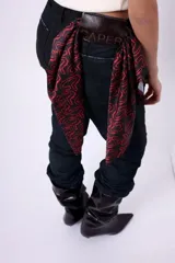 Pañuelo cuadrado de seda con diseño estampado de letras en color rojo sobre fondo negro.