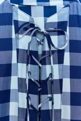 Vestido midi de Zara Woman Collection confeccionado en mezcla de viscosa, con estampado de cuadros en tonos azul y celeste. Presenta cuello redondo, manga corta, bolsillos ocultos en las costuras y cierre frontal con cordones entrelazados.