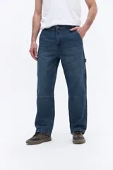 Jean estilo carpenter de inspiración workwear, con corte relajado y tiro medio. Presenta costuras reforzadas en las rodillas y bolsillo lateral funcional.