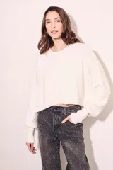 Sweater color crema de tejido de punto, corte crop y mangas abullonadas.