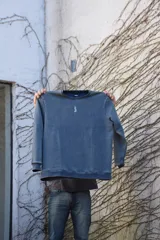 Buzo azul con efecto lavado, cuello redondo y logo bordado en el pecho.