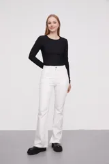 Pantalon jean de tiro alto con corte flare y terminación desflecada en el ruedo. Presenta un diseño clásico de cinco bolsillos con costuras en contraste.