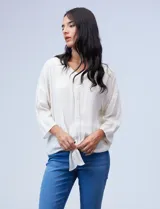 Blusa texturada color blanco, con escote en V con bordado, manga larga de largo regulable y ruedo con nudo.